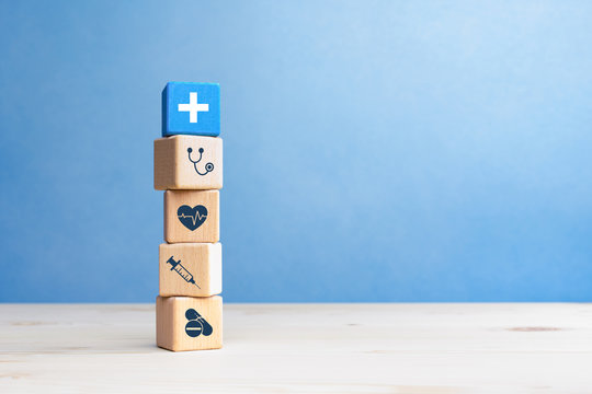 Health insurance concept, wooden blocks with healthcare medical icons on blue background, copy space