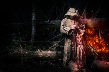 A monk in a cassock walks through the night forest with a sword and a lantern. Burning wood. Fiery sword. The magic monk.
 - obrazy, fototapety, plakaty