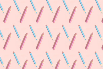 Pattern of colorful pencils. Pastel pink and blue pencils on pink background. Back to school, education and learning concept. Minimalist isometric concept.