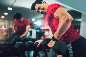 Young handsome man doing exercises in gym