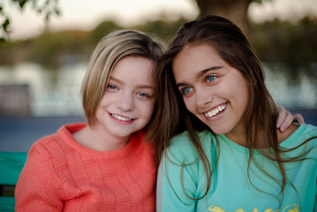 Obraz premium Two smiling girls. Best friends. Two friends. Happy female students having fun together. Two young girls in the evening outside 