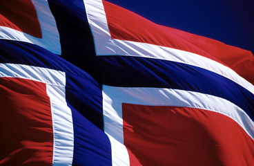 The Norwegian flag - large - waving in the wind during summer time