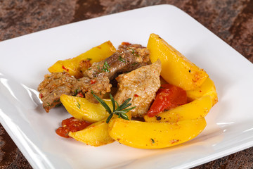 Baked pork meat with potao and tomato