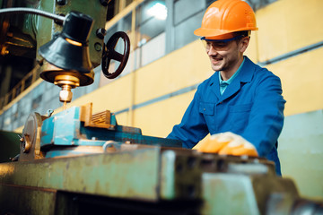Turner in uniform and helmet works on lathe, plant © Nomad_Soul