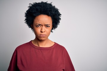 Obraz premium Young beautiful African American afro woman with curly hair wearing casual t-shirt standing skeptic and nervous, frowning upset because of problem. Negative person.