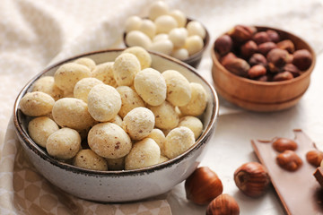 Tasty candies in bowl on table