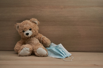Teddy bear wearing mask, ideas concept for parents to convince children to wearing mask to protect the young children from catching Coronavirus COVID-19. copy space