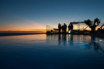 Fototapeta na wymiar business people silhouette backlight in swimming pool at sunset with space to write