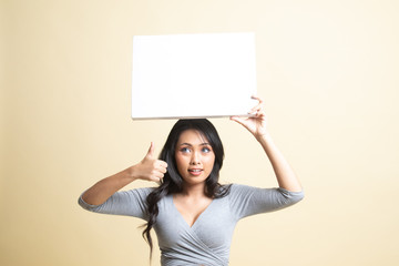 Young Asian woman show thumbs up with white blank sign.