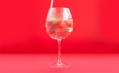 Bright juicy selected strawberries in a large glass with soda.