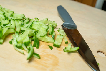 Delicious fresh sliced cucumber on a wooden cutting Board with a knife