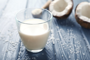 Glass of tasty coconut milk on table