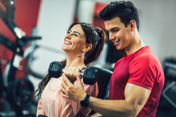 Young beautiful woman doing exercises with personal trainer