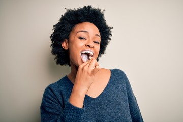 Fototapeta na wymiar African american woman brushing her teeth using tooth brush and oral paste, cleaning teeth and tongue as healthy health care morning routine