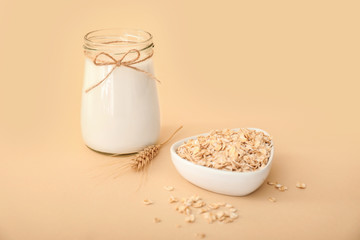 Jar of tasty oat milk on color background