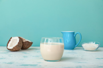 Glass of tasty coconut milk on table