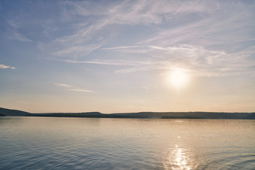Beautiful sundown on lake with rocky shore.