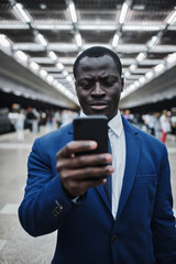 Businessman with smart phone on subway station