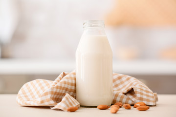 Bottle of tasty almond milk on table