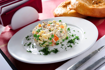 Russian traditional salad Olivier, isolated on table.