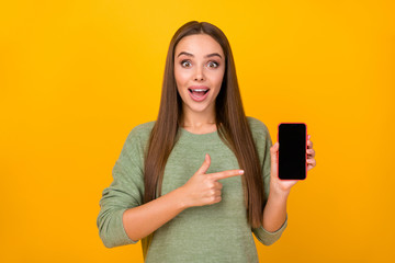 Portrait of astonished excited crazy girl hold cellphone impressed new gadget functions like point...