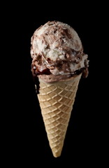 Cones with chocolate and vanilla ice cream scoops isolated on black background with clipping path