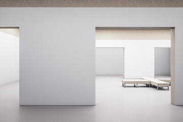 Modern gallery hall interior with blank concrete wall and bench.