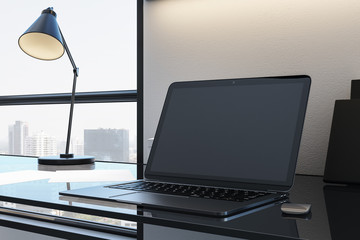 Designer desktop with empty black laptop screen