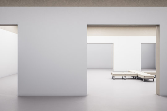 Modern gallery hall interior with blank concrete wall and bench.
