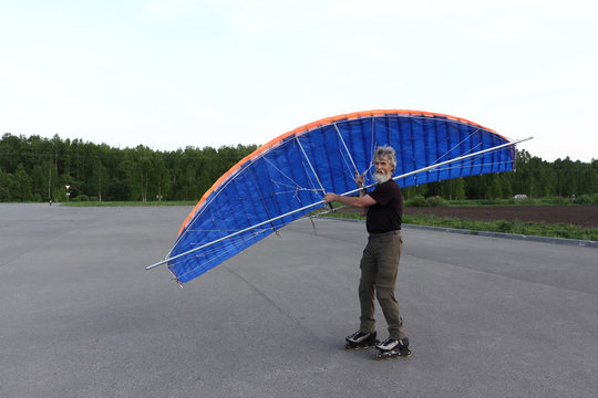 Man training in roller skating with  kite