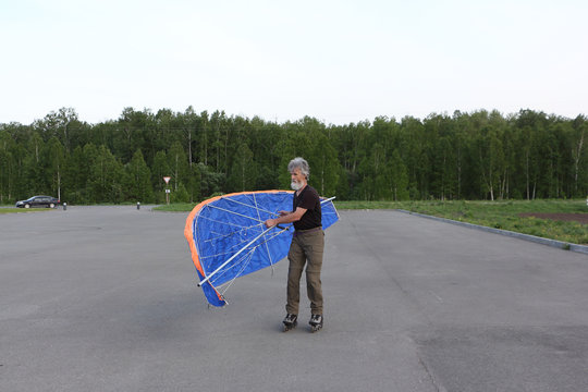 Man training in roller skating with  kite