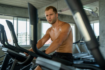 Fototapeta na wymiar Fitness man running on modern electric treadmills at the gym,Man on electric treadmills.