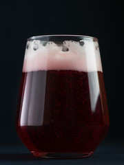 Cherry beer craft ale in a trendy glass on a black table