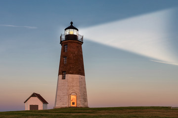 Lighthouse beam at sunset. Point Judith lighthouse, Rhode Island, USA