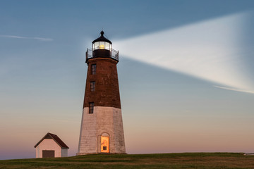 Lighthouse beam at sunset. Point Judith lighthouse, Rhode Island, USA