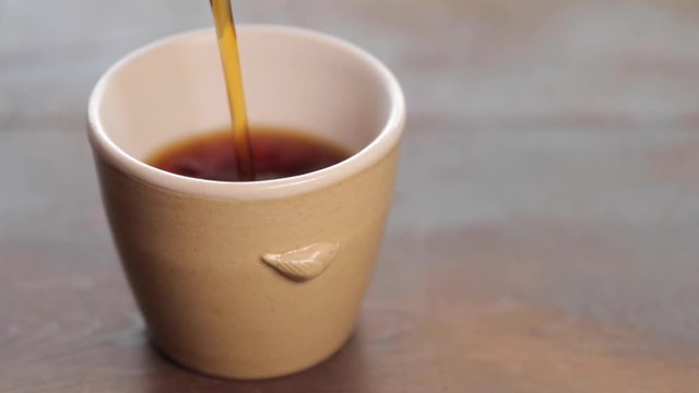 Pour coffee in the tiny cup.