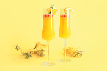 Glasses of tasty mimosa cocktail on color background