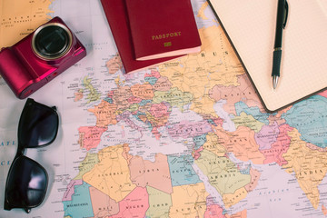 Travel concept on map background. travel plannig. top view of traveler's accesories and copy space. two passports, camera, notebook on world map. preparation for travel.