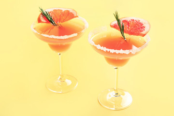 Glasses of tasty mimosa cocktail on color background