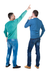 Obraz premium Back view of two man in sweater pointing.