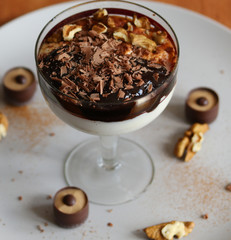 cottage cheese dessert with chocolate and walnuts on a white plate close up