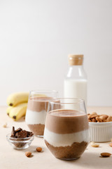 Chia seeds pudding with chocolate and banana smoothie in a glass on beige background