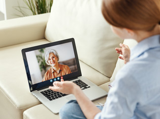 Young woman having video call with eldery mother on tablet.
