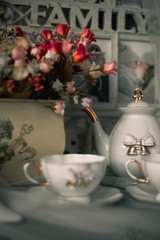 still life ceramic dishes with bow. flowes in a pot. Family photo frame.
