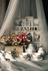 still life ceramic dishes with bow. flowes in a pot. Family photo frame.