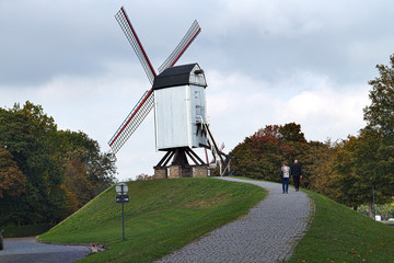 Obraz premium Windmill in the countryside against the backdrop of the sky and cobbled pathway leading to it