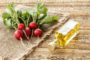 Ripe red radishes with green leaves on sackcloth and wooden boards.