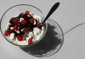 cottage cheese with chocolate and dry cherries in a glass bowl