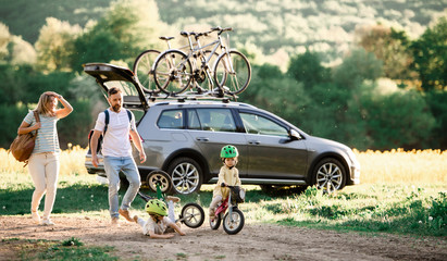 Family with two small children going on cycling trip in countryside.
