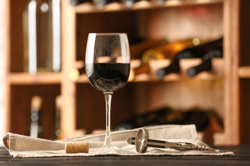 Fototapeta na wymiar Glass of wine on table in cellar